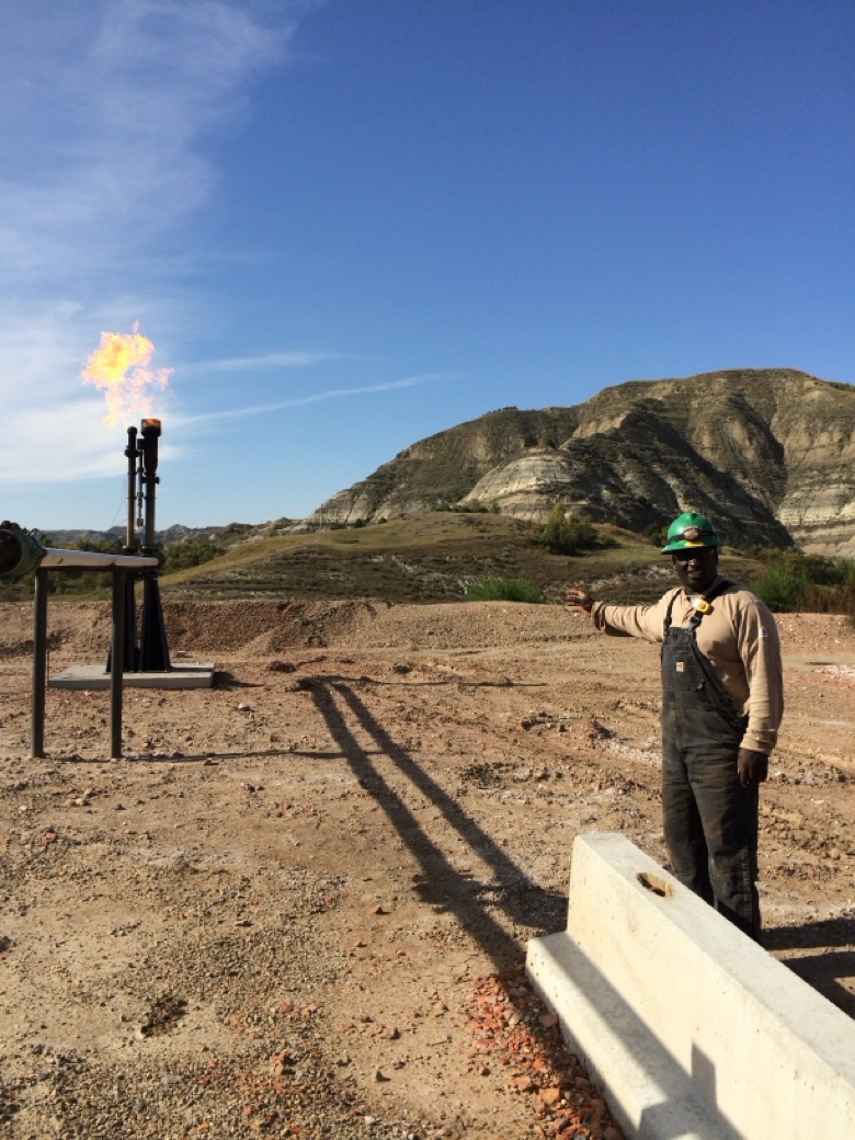 Lester Bain in hard hat at an oil and gas field flare stack